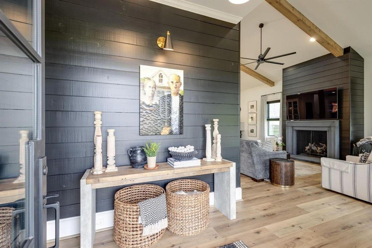 Rustic entryway with a shiplap accent wall, console table, and woven baskets underneath.