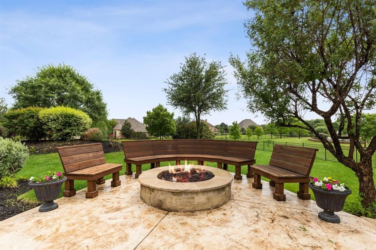 Firepit area with circular stone seating and vibrant greenery.