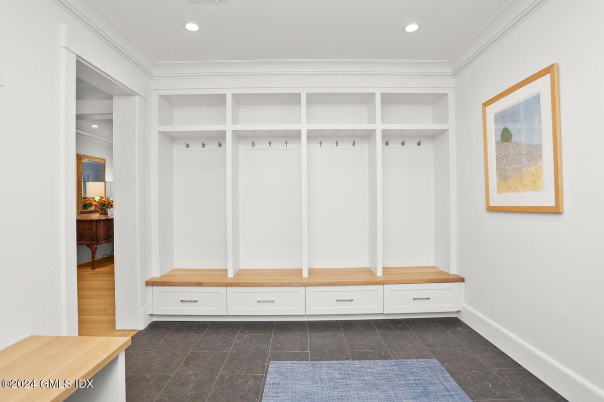 Hallway has built-in cubbies, wood flooring, and artwork.