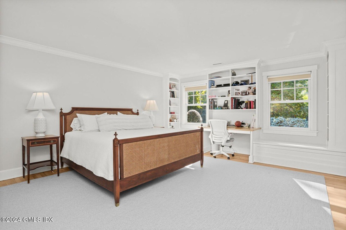 Bedroom has a large bed, built-in shelves, and a desk.