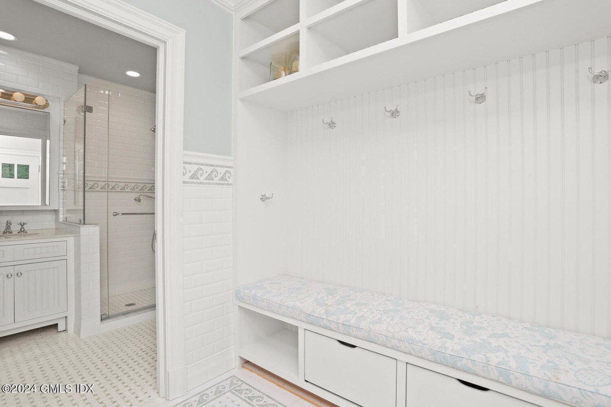 Bathroom has white subway tile, a built-in bench, and a shower.