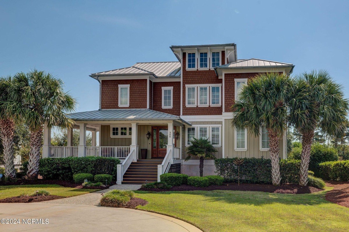 house has a covered front porch with white columns and railings.