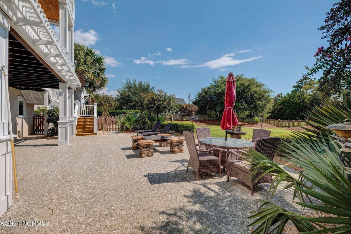 Patio has seating area, fire pit, and lawn.