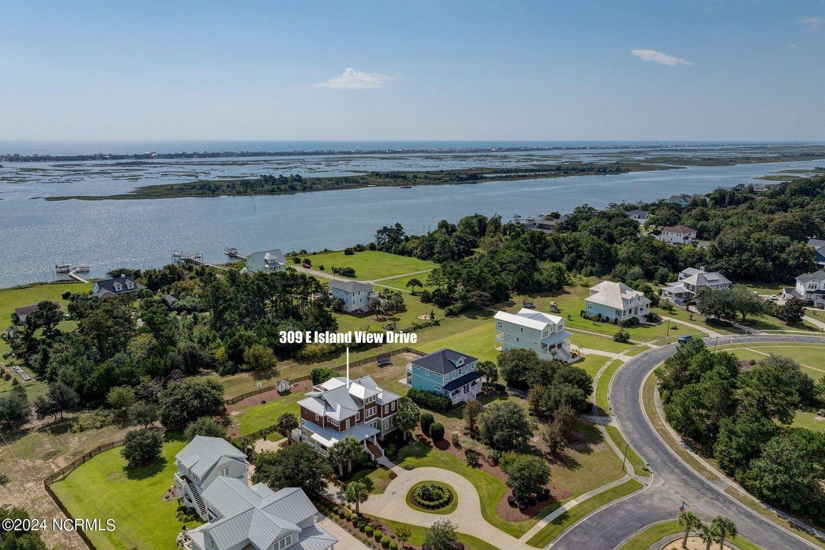 Aerial view shows waterfront property and surrounding houses.