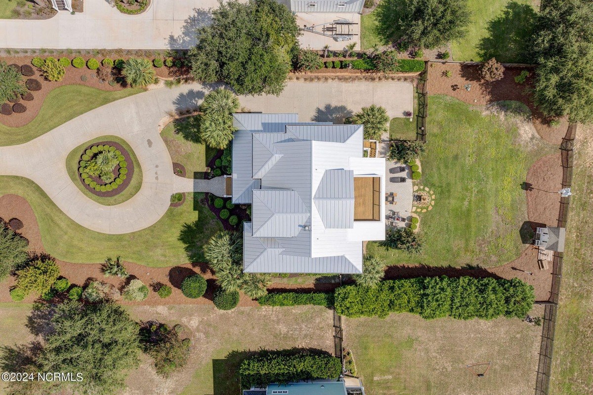 Overhead view shows house with metal roof and landscaping.