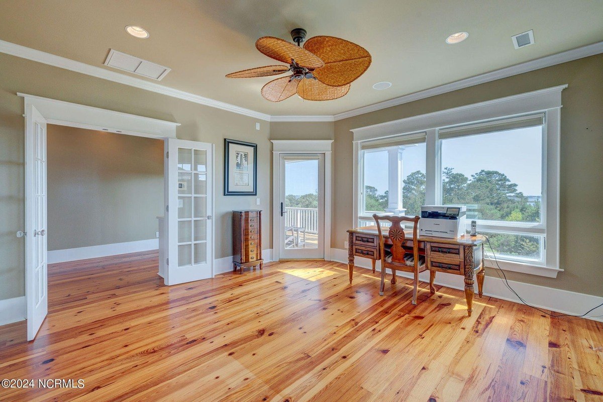 Room has hardwood floors, ceiling fan, and desk.