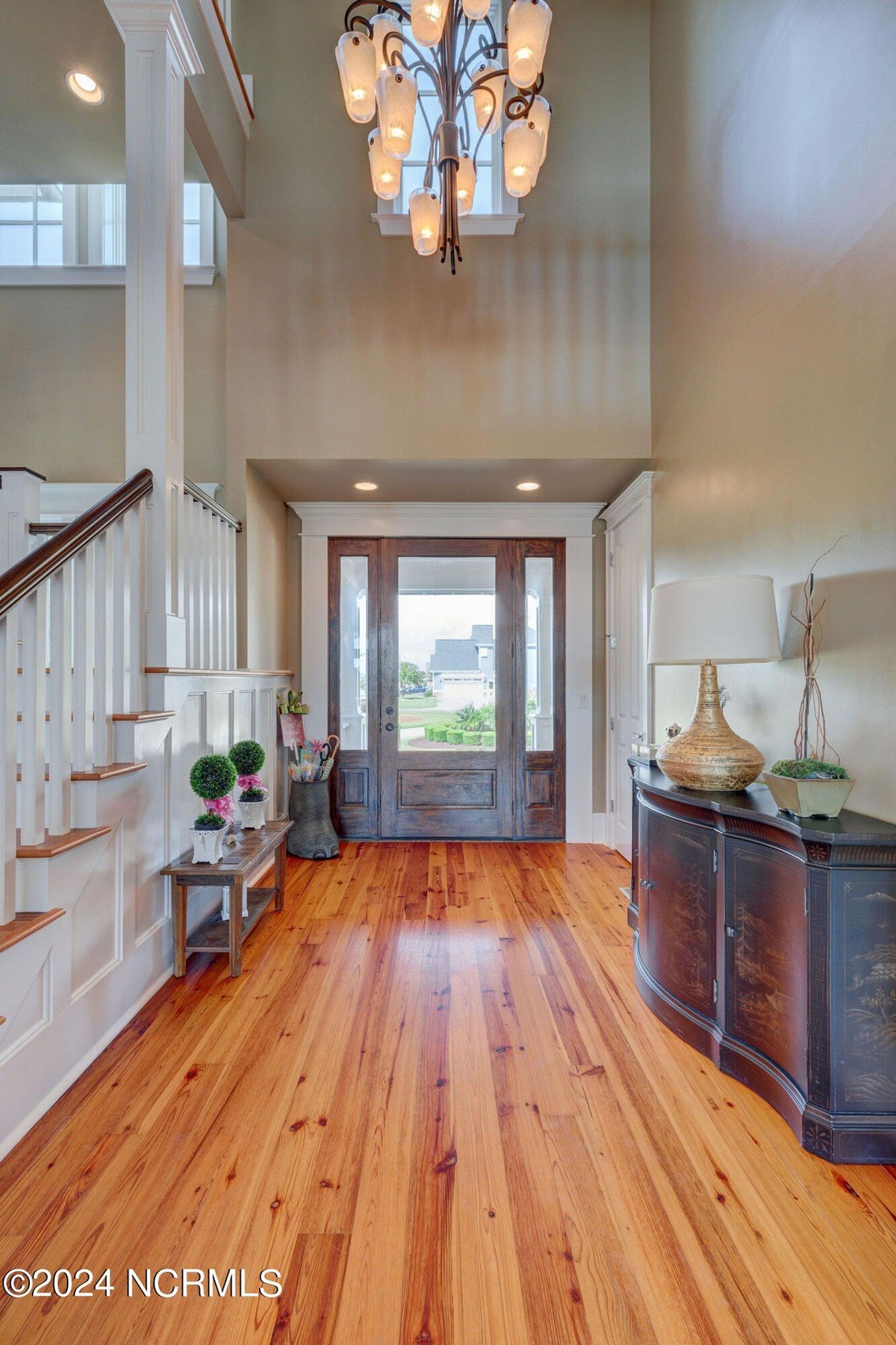 Entryway has hardwood floors, chandelier, and stairs.