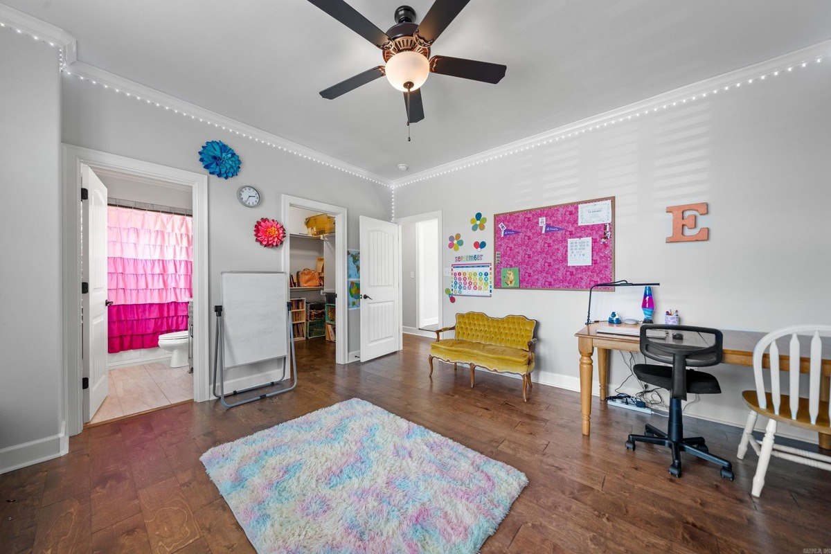 Playroom with a desk, seating area, and a view into a bathroom.