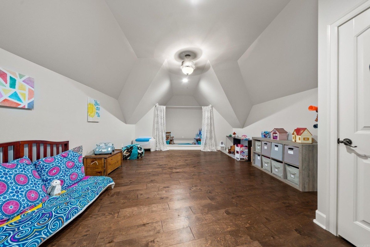 Playroom in attic space with hardwood floors and a seating area.