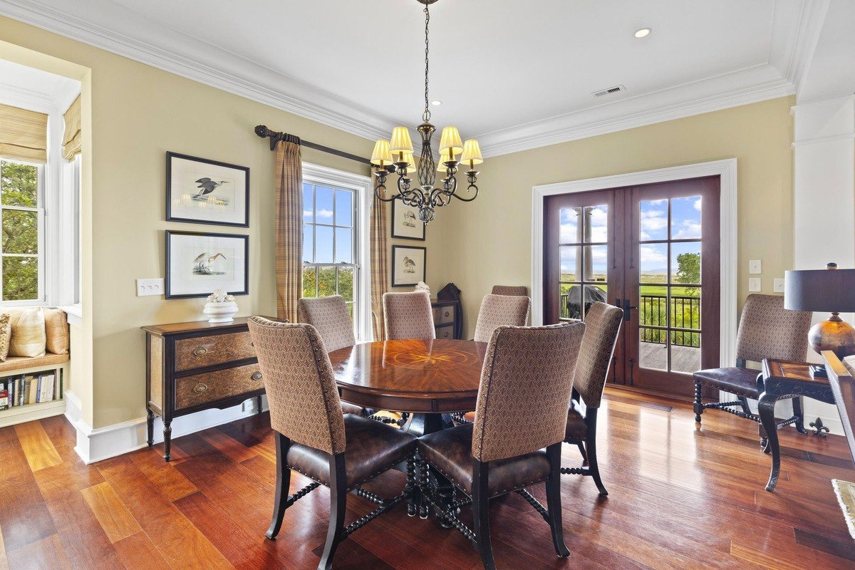 Dining room features hardwood floors, a round table with chairs, and a chandelier.