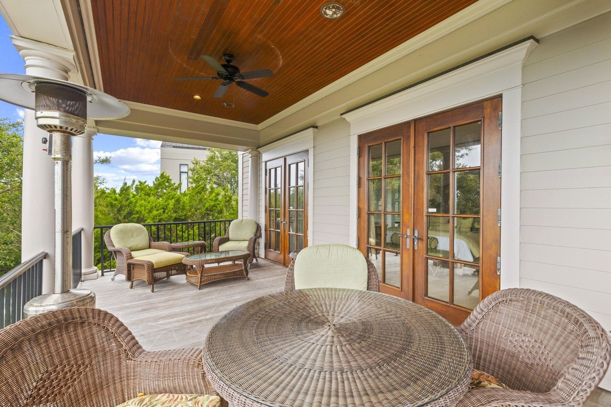 Porch has wicker furniture, a ceiling fan, and a wood-paneled ceiling.