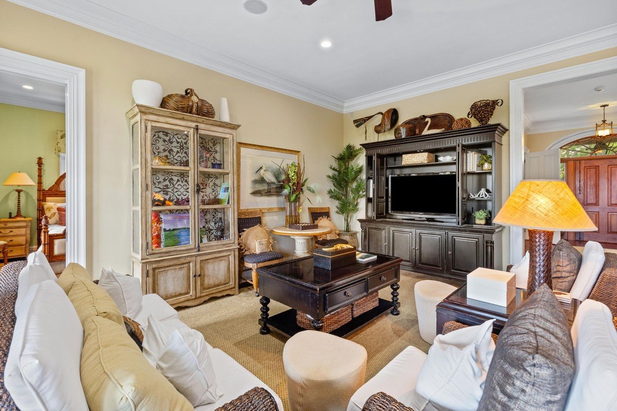 Living room features a large entertainment center, comfortable seating, and a display cabinet.