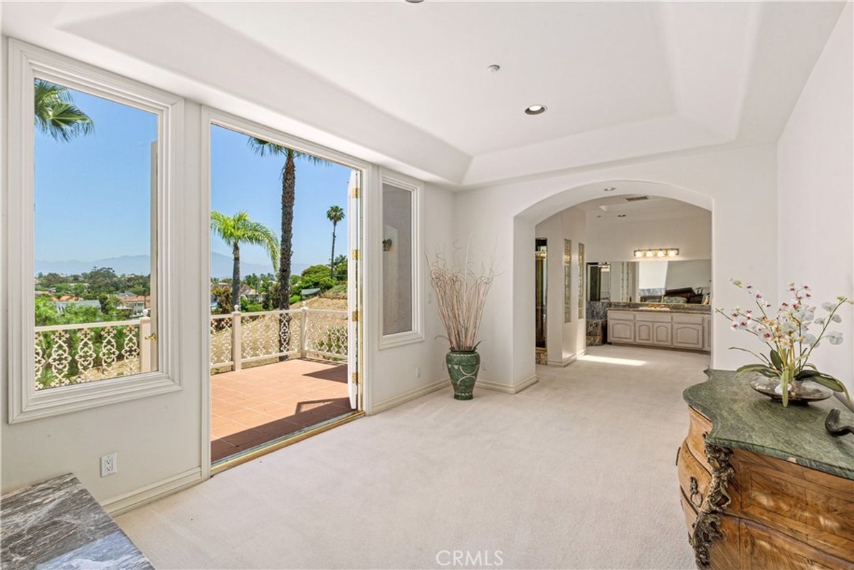 Elegant hallway leads to a balcony with outdoor access and bathroom space.