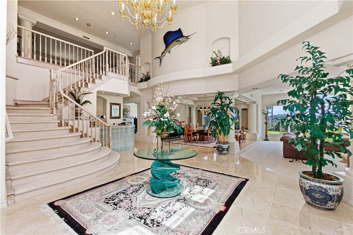 Sweeping staircase with an open-concept layout featuring elegant decor and a centerpiece table.