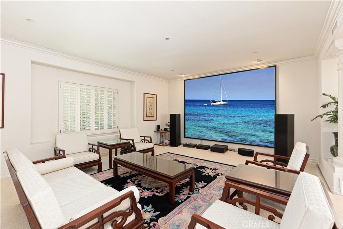 Entertainment room featuring a large projection screen and elegant traditional furniture.