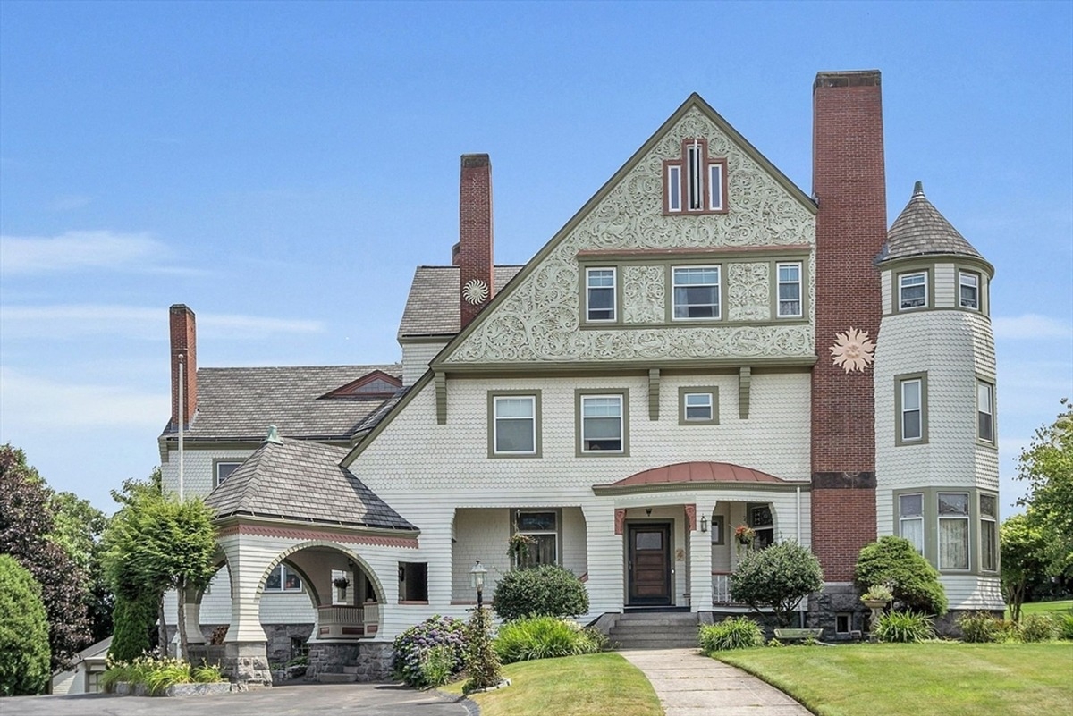 Ornate historical house with intricate gable and brick chimney details.