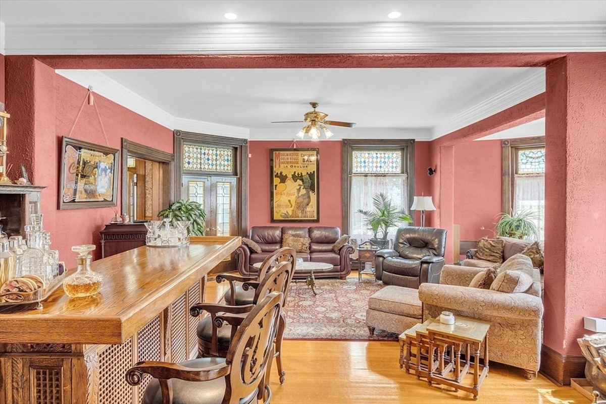 Spacious living room features a built-in bar, stained glass accents, and a seating arrangement for relaxation.