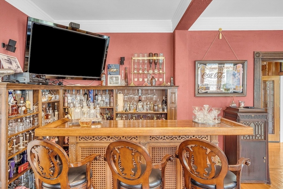 Elegant bar area is decorated with an array of glassware and a wooden countertop.