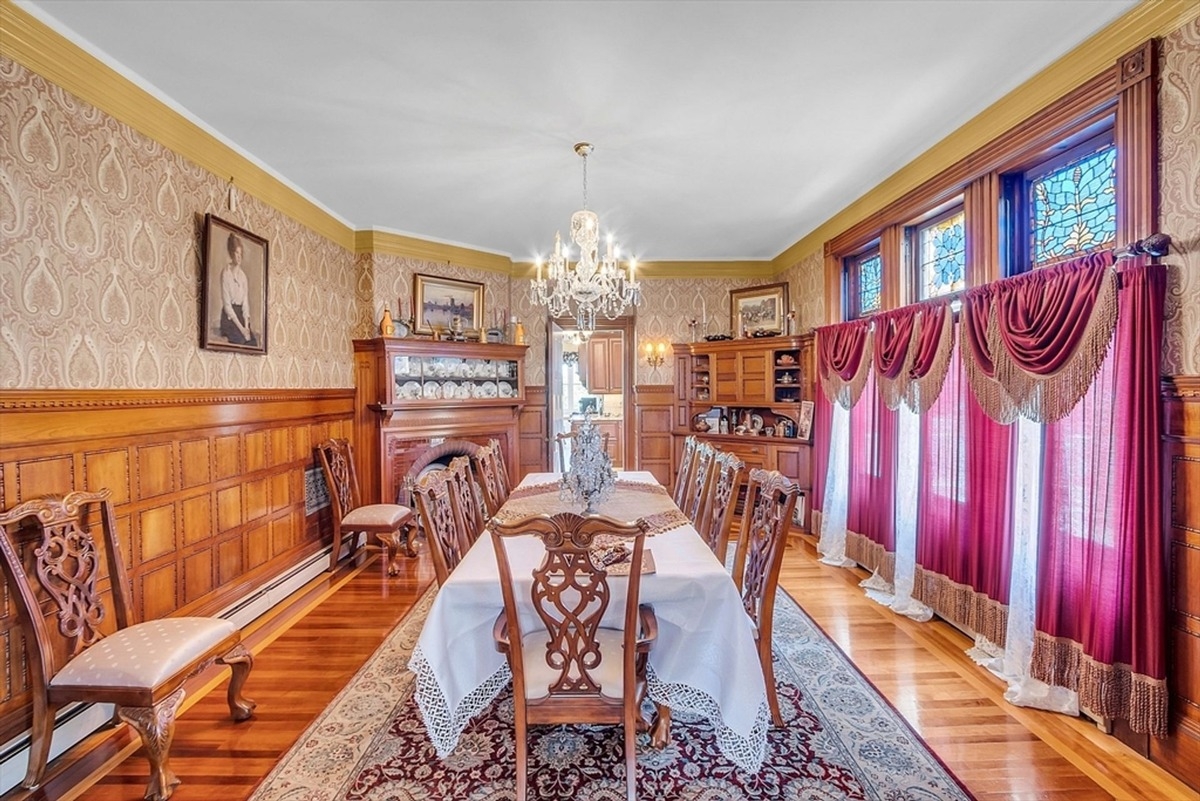 Dining space includes built-in wooden cabinets, a decorative fireplace, and a china display with elegant trim details.