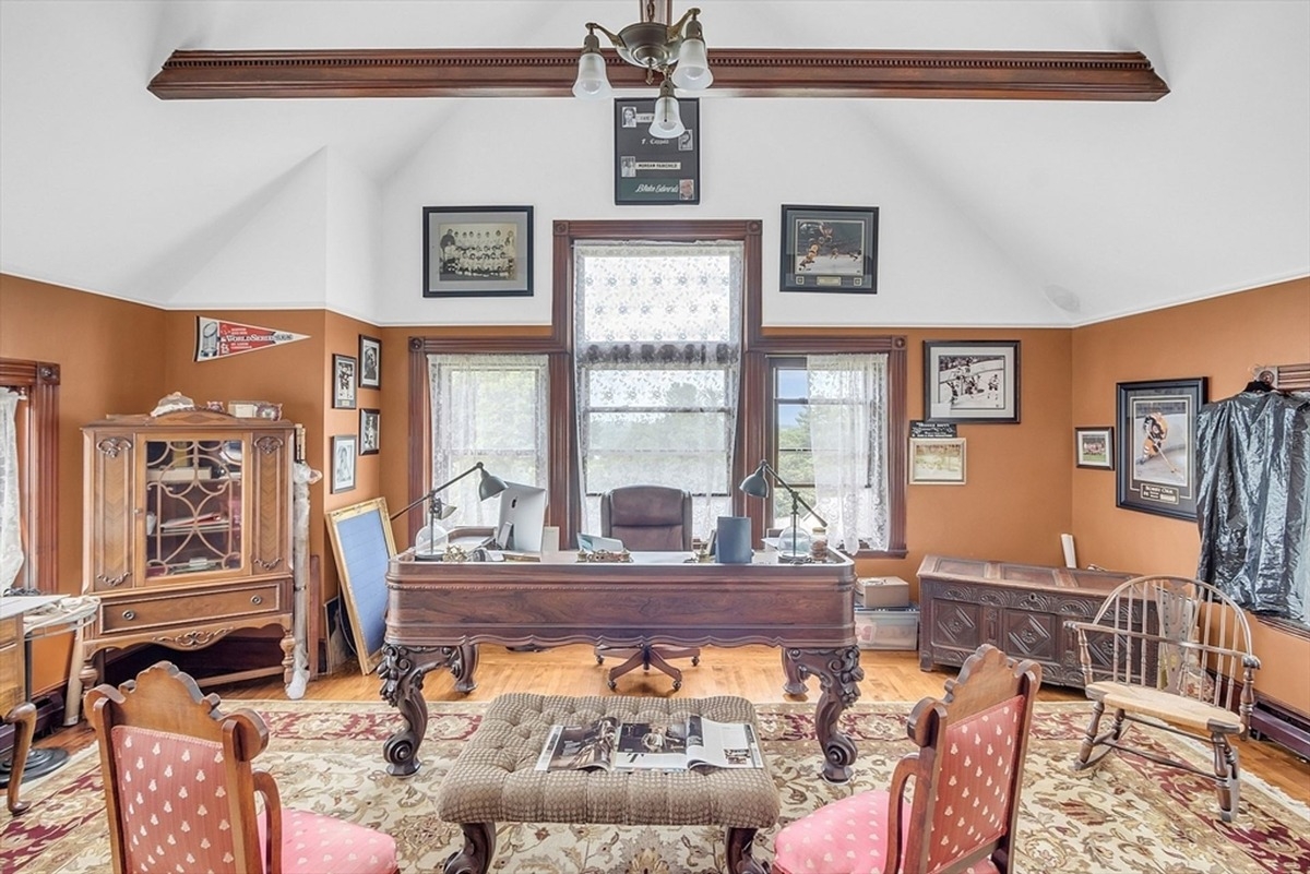 Home office includes a traditional desk, vintage decor, and framed memorabilia on the walls.