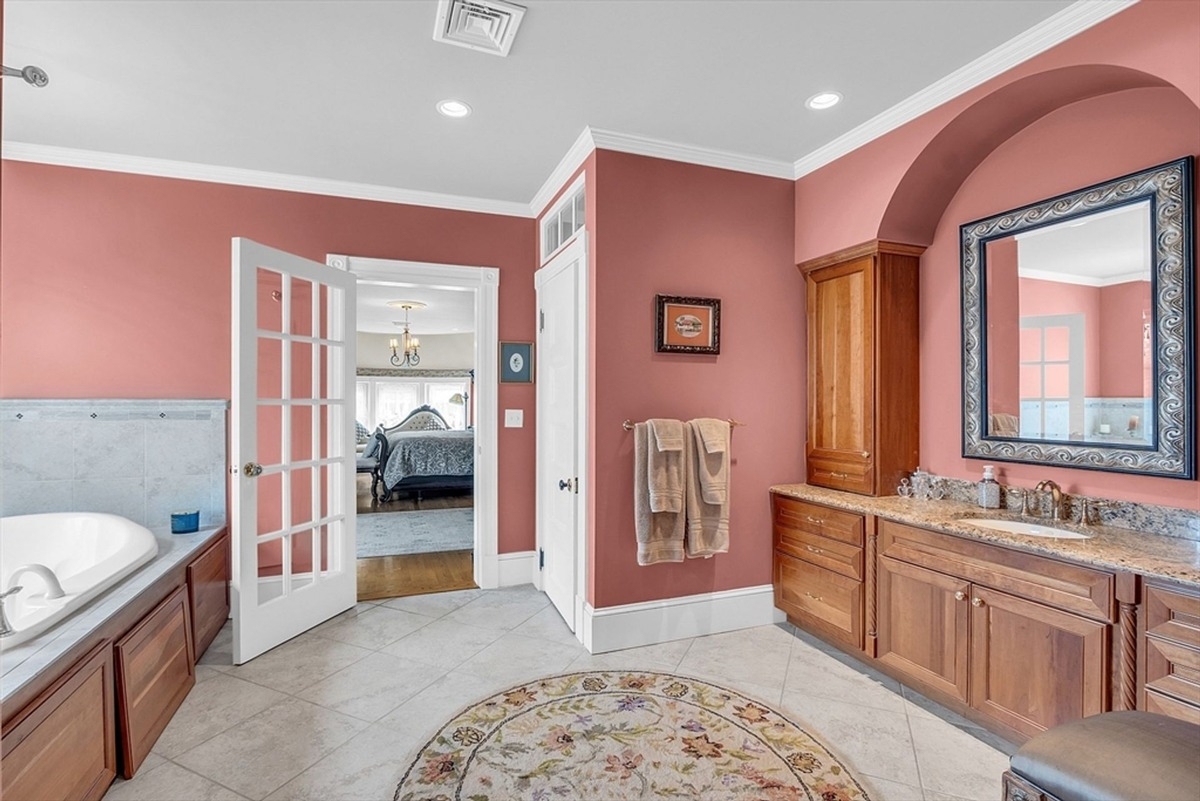 Bathroom includes a soaking tub, dual vanity, and French doors connecting to the bedroom.