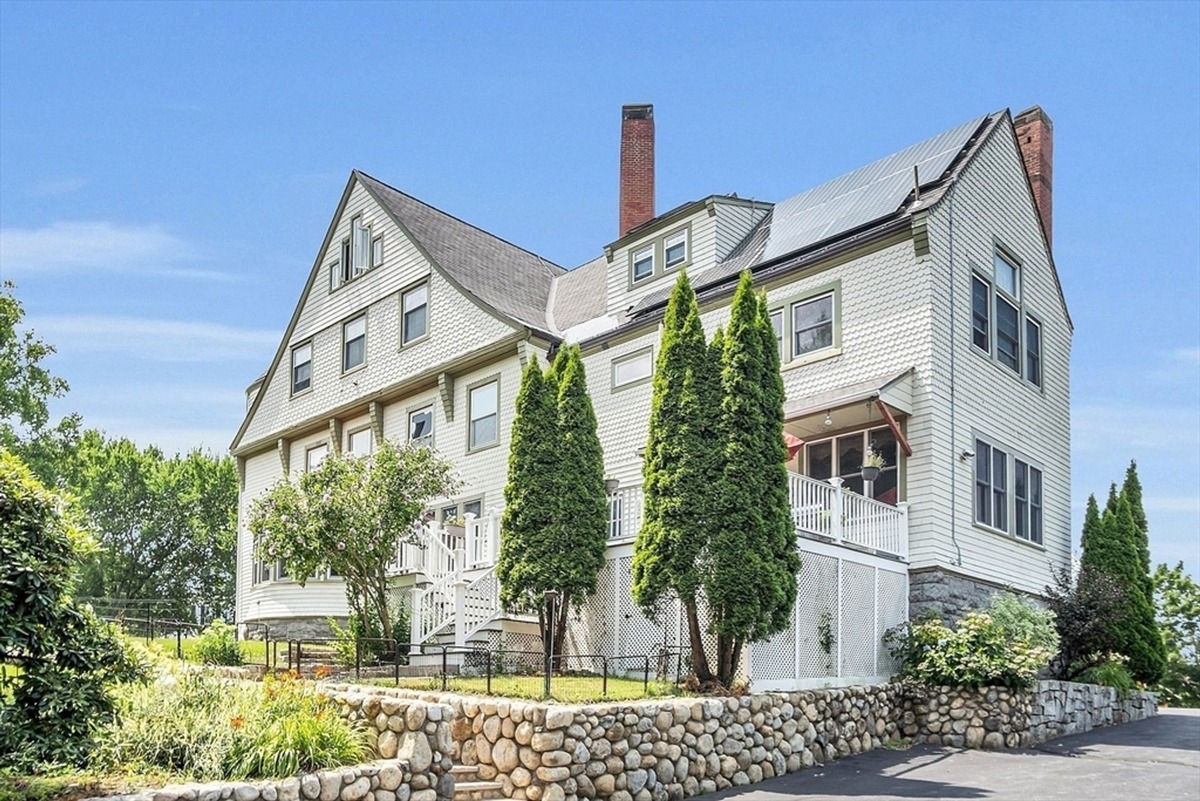 Exterior showcases a large multi-story house with manicured landscaping and stone retaining walls.