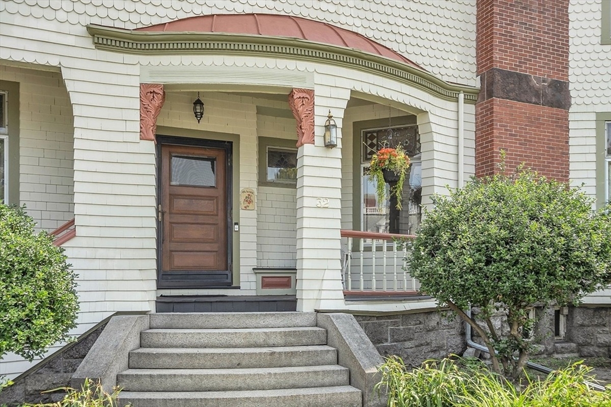 Front porch entrance featuring a decorative awning and a classic wooden door.