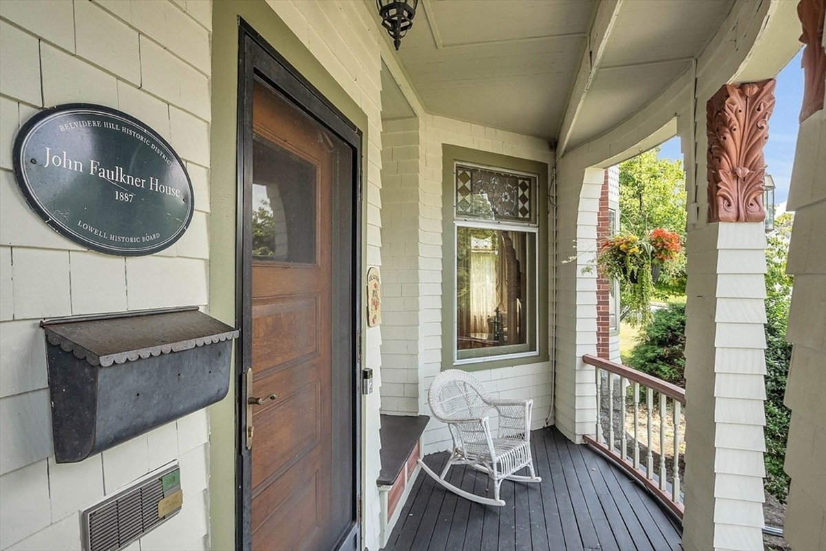 Curved porch area with rocking chair and historical plaque denoting the John Faulkner House.