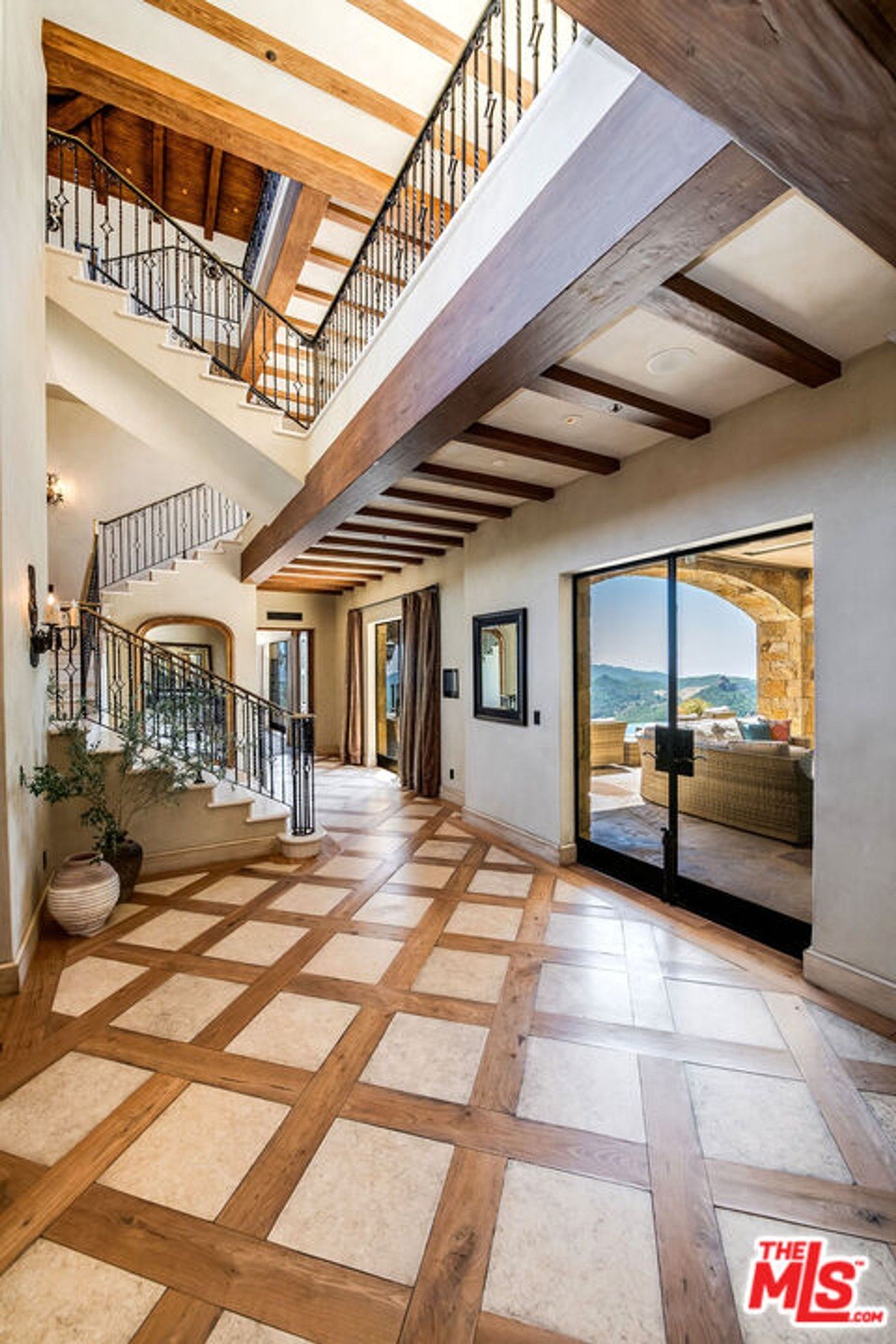 Expansive courtyard with ivy-covered garage doors and arched stone architecture.