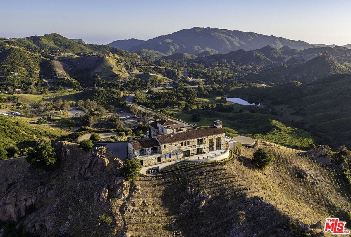 Aerial view of the mansion nestled on a hilltop, showcasing its expansive grounds and scenic surroundings.