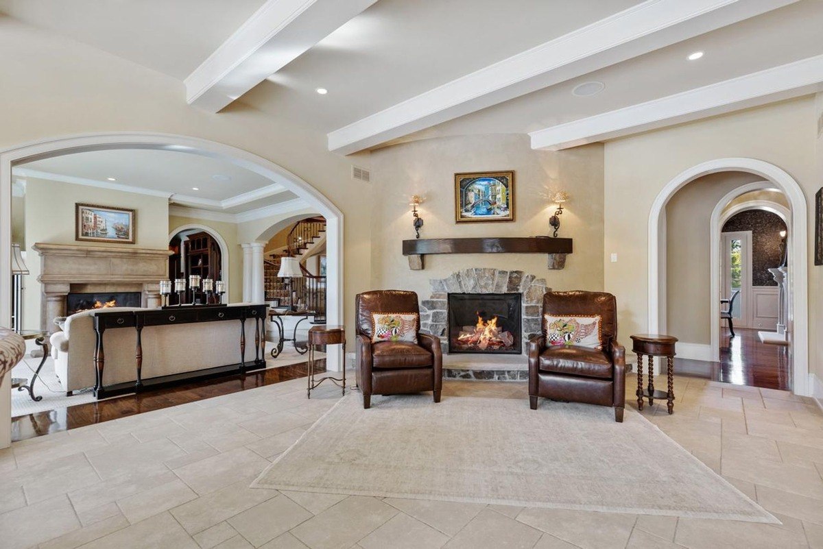 Sitting area with two armchairs flanking a crackling fireplace offers a warm and inviting space to relax.