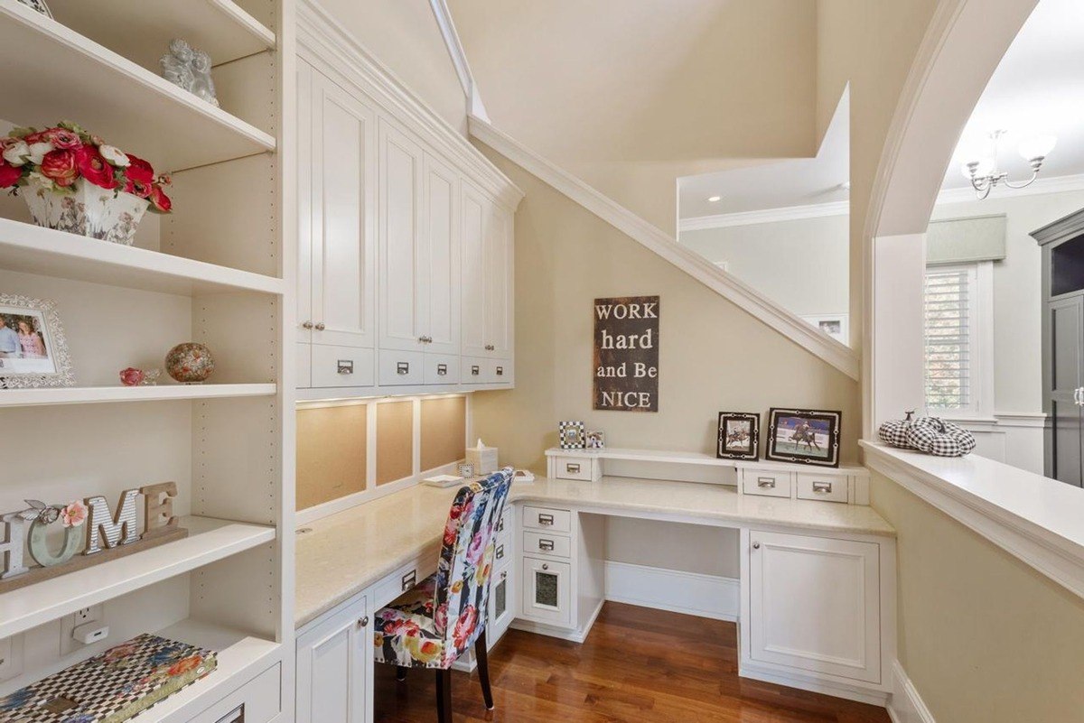 Cozy home office nook with built-in shelving, a desk, and a colorful chair offers a dedicated space for work or study.