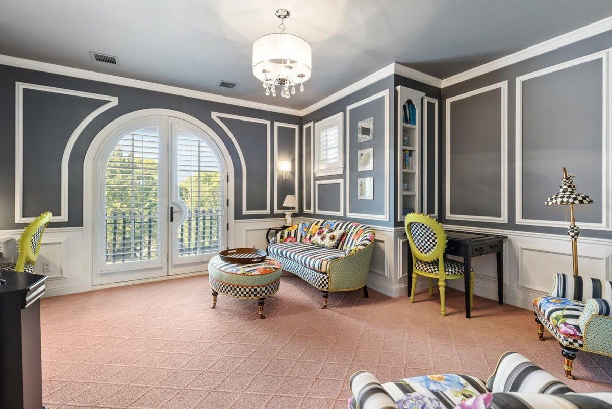 Sitting room stylish lounge area with patterned walls, arched doors, and colorful furniture.