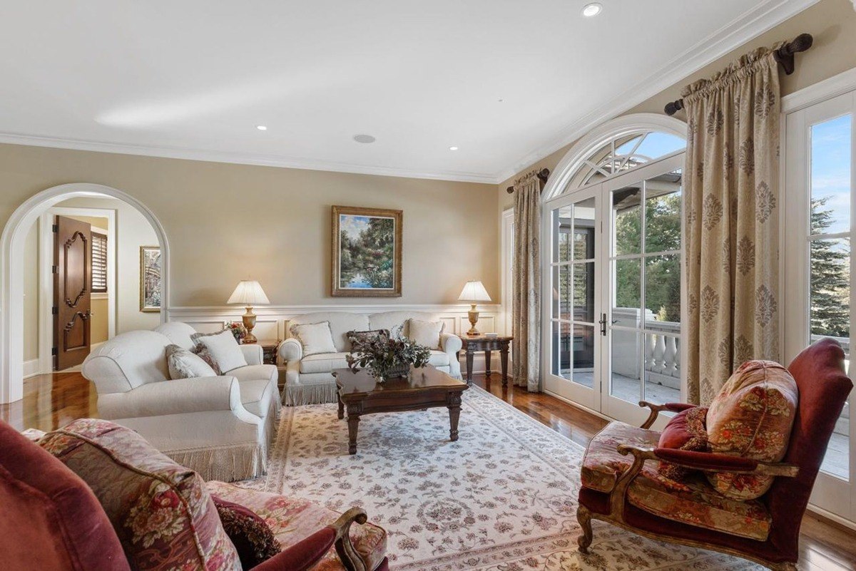 Living room with plush seating, elegant draperies, and arched doorways creates an inviting and sophisticated atmosphere.