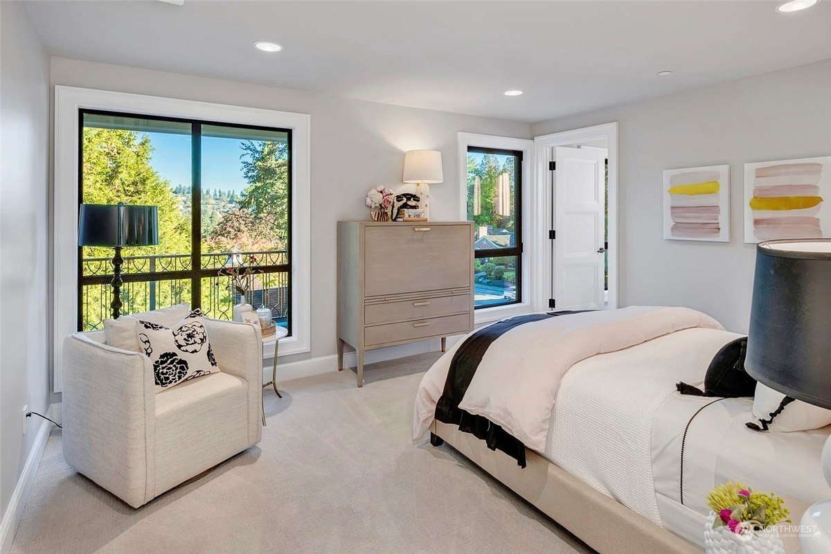 Bedroom has neutral colors, carpeted floor, and a view from a large 