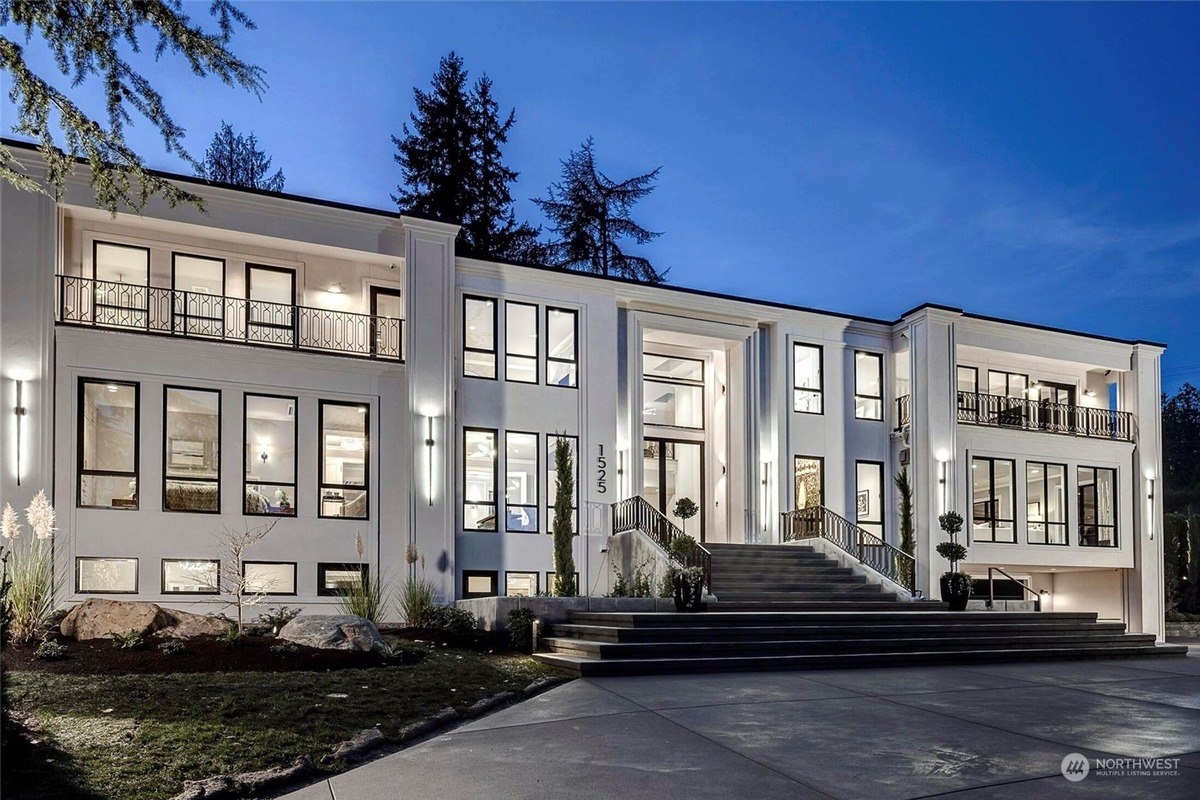 Grand façade with a white exterior, symmetrical windows, and wide entrance steps leading to double doors.