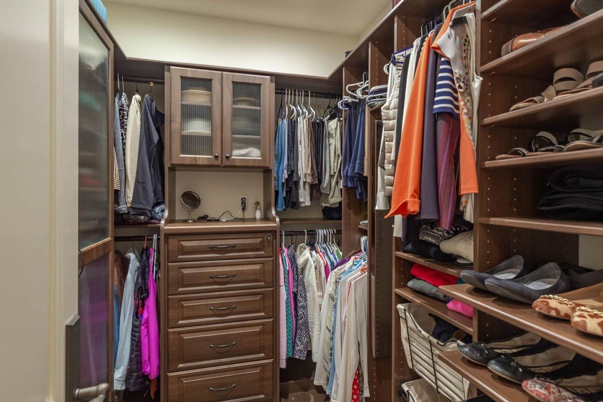 Walk-in closet featuring wooden built-ins, ample shelving, and clothing racks.