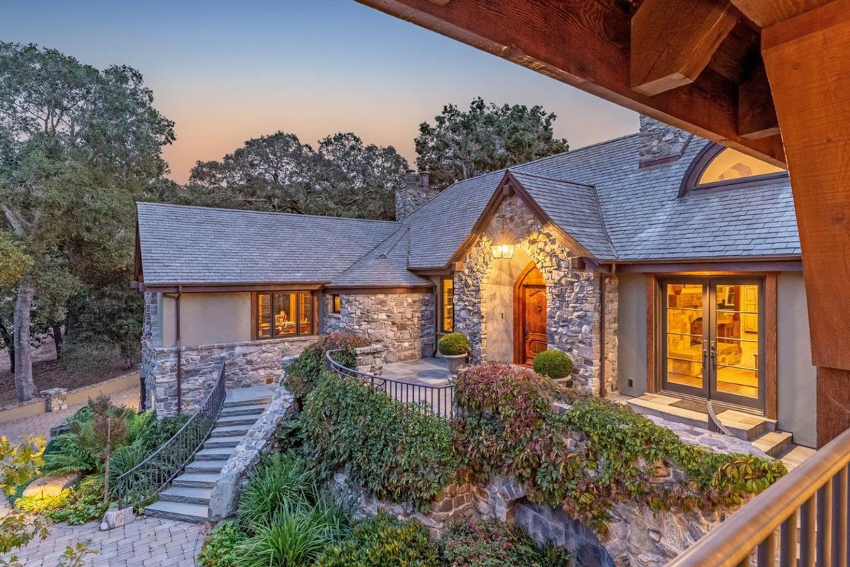 Front entrance at dusk, the stone-clad entrance is lit, highlighting architectural details.