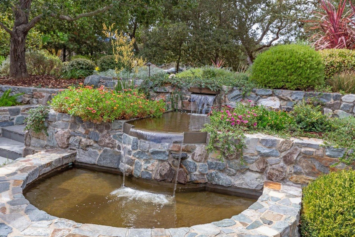 Tiered water feature a multi-tiered stone fountain surrounded by greenery.