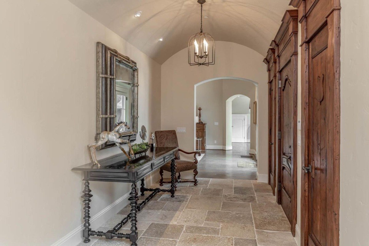 Entryway with arched ceilings, stone flooring, and decorative furniture.