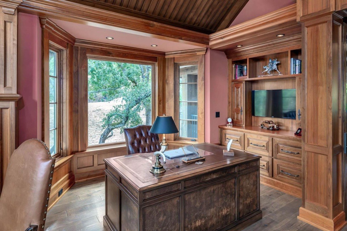 Desk area in the home office with built-in shelves and garden views.