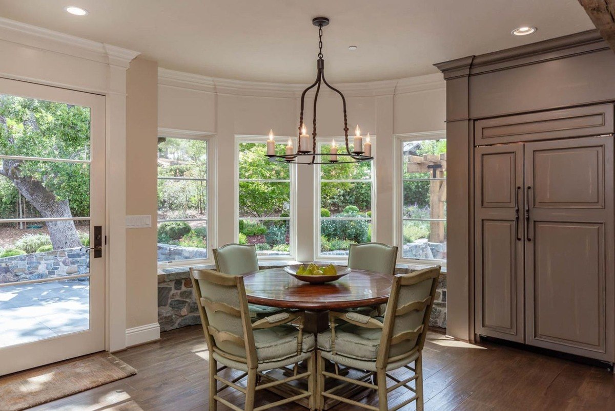 Breakfast nook surrounded by windows overlooking the garden.