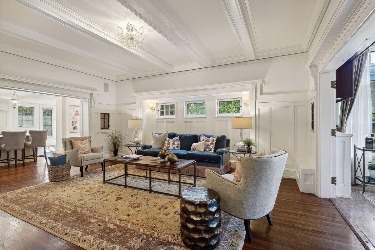 Living room with a navy blue sofa, patterned rug, and hardwood floors.