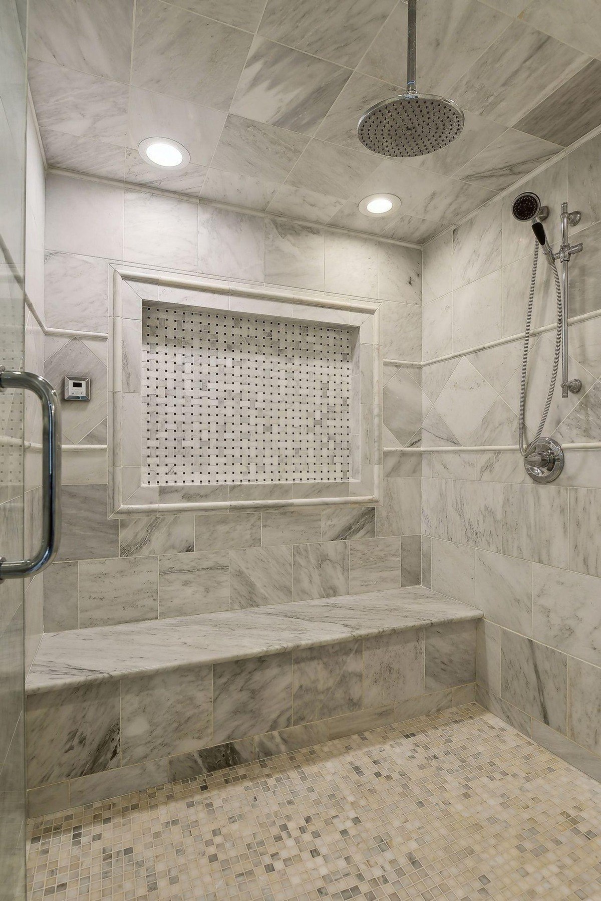 Shower with marble tile, built-in seat, and multiple shower heads.