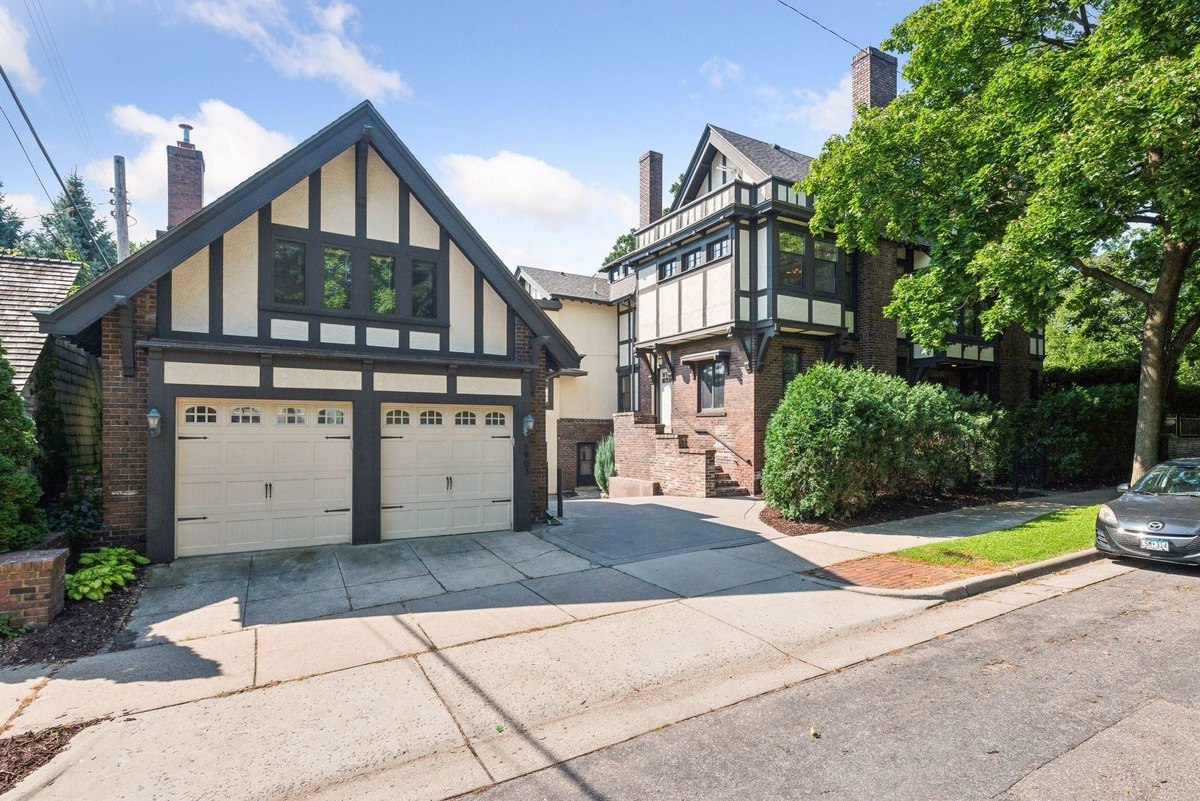 Two-story house with a detached garage, both in Tudor style architecture.