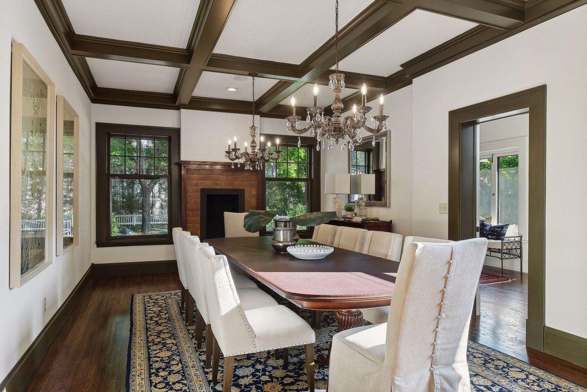 Formal dining room with a large wooden table, chandelier, and hardwood floors.