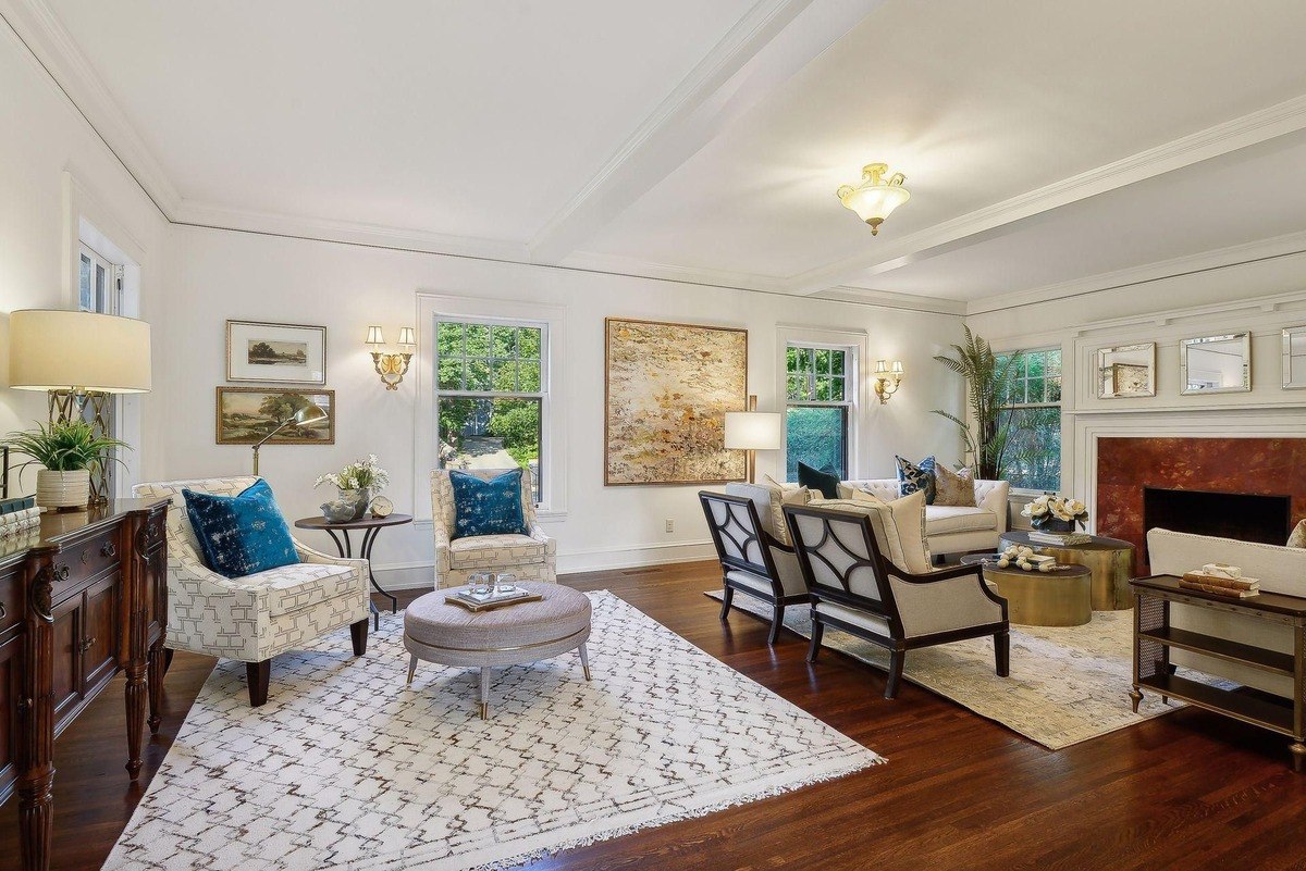 Living room with hardwood floors, a large area rug, and comfortable seating arranged around a coffee table.