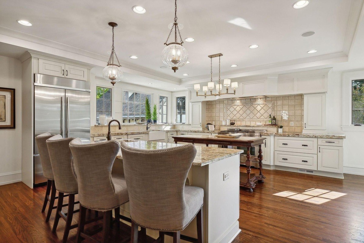 Kitchen with granite countertops, white cabinets, and hardwood floors.