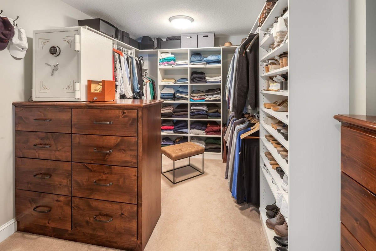 Walk-in closet with custom wood cabinetry and organized shelving.