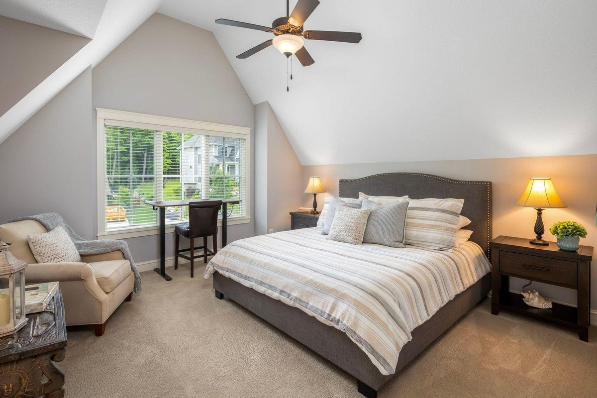 Spacious bedroom with vaulted ceilings and a reading nook by the window.